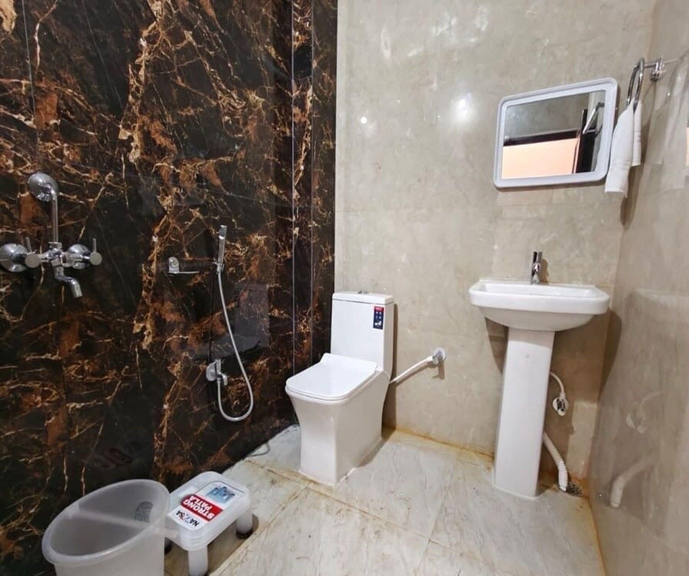 Une salle de bain équipée de toilettes, d’un bidet, d’un lavabo et d’un miroir.