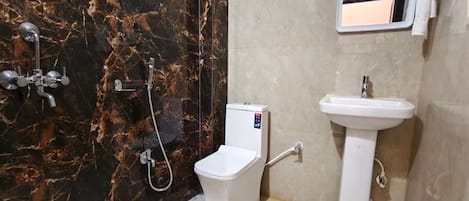 Une salle de bain équipée de toilettes, d’un bidet, d’un lavabo et d’un miroir.