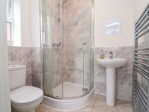 A bathroom with a glass-enclosed shower, a toilet, and a pedestal sink. - Corbetts Close (Crewe)