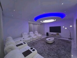 A modern living room with a sectional sofa, a round coffee table, and a flat-screen TV.