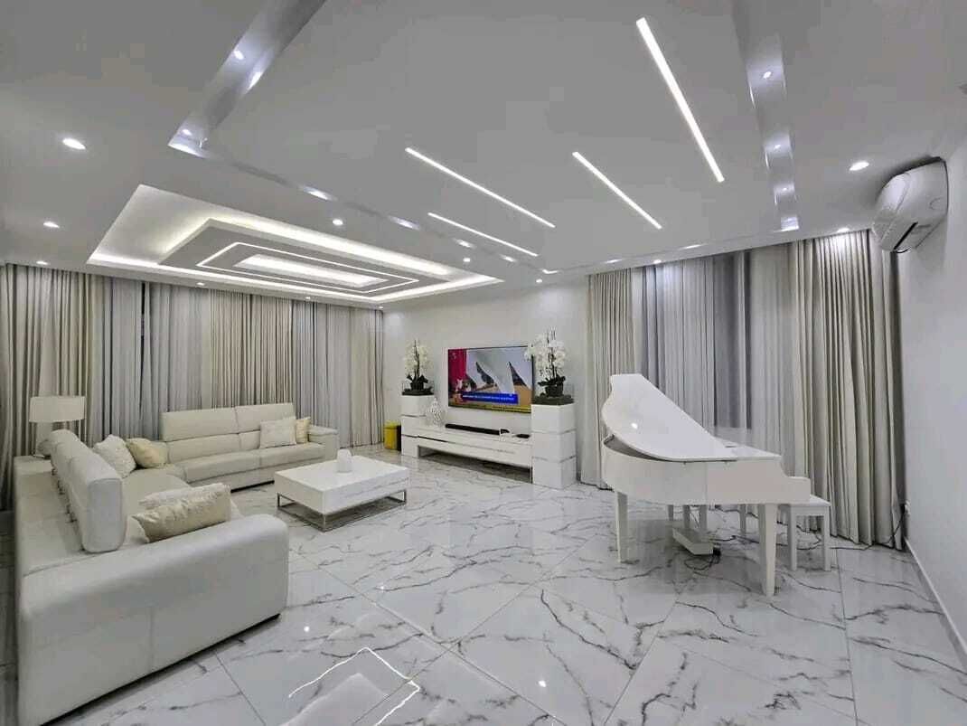 A modern living room with a sofa, coffee table, and a grand piano.