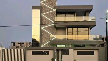 A modern multi-story building with a prominent vertical element and a series of windows on the upper floors.