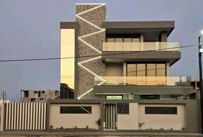 A modern multi-story building with a prominent vertical element and a series of windows on the upper floors.