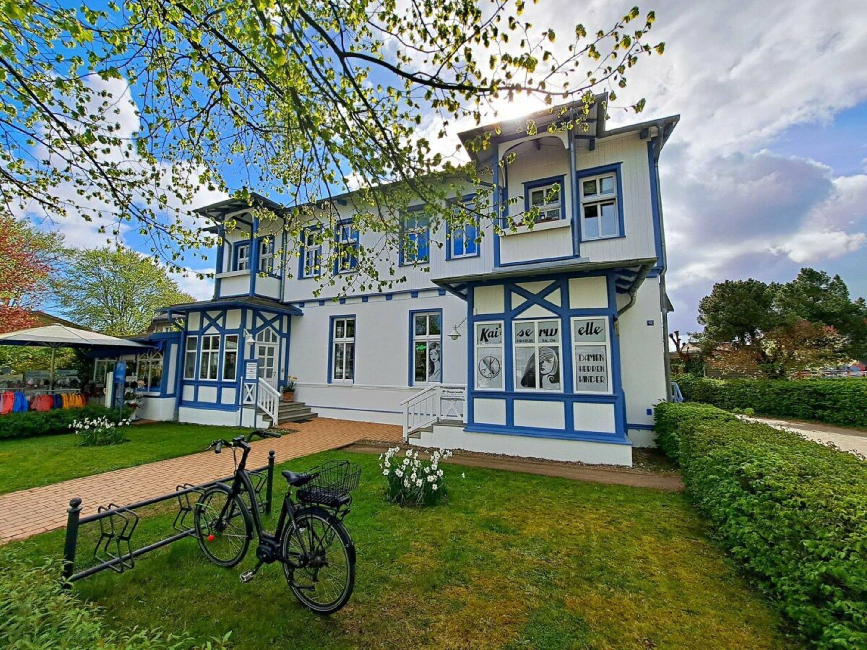 Ein zweistöckiges Gebäude mit Balkon und einem Fahrrad davor.