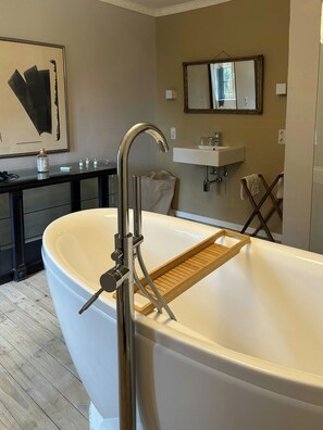 A modern bathroom with a freestanding bathtub, a wooden bath tray, a sink, and a mirror. - Historic Apartment in a Bavarian Palace (Unterschwaningen-Dennenlohe)