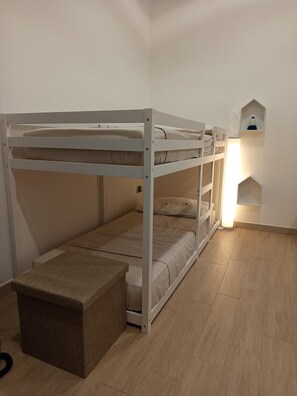 A bunk bed with a bench at the foot, a bedside table, and a wall-mounted shelf with a lamp. - Holiday Home 'La Bouganville' with Wi-Fi (Trinitapoli)