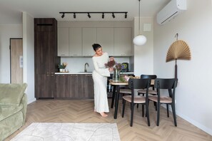 A modern kitchen with a dining area, a sofa, and a fan.