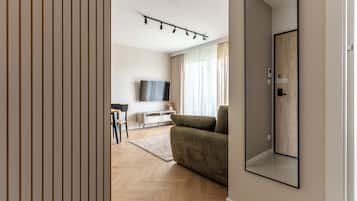 Una sala de estar moderna con un sofá, un televisor y piso de madera.