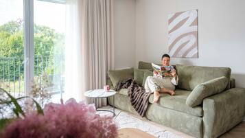 Apartamento superior, 1 quarto, ar-condicionado | Área de estar | TV de tela plana 40 polegadas com canais a cabo, Netflix, Hulu
