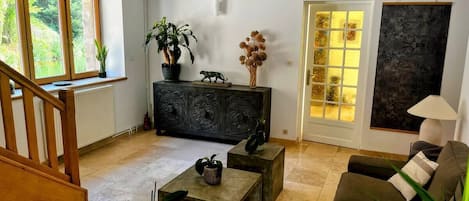 A living room with a sofa, coffee table, and a cabinet with decorative items.