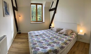 Ein Schlafzimmer mit Bett, Fenster und Heizkörper.