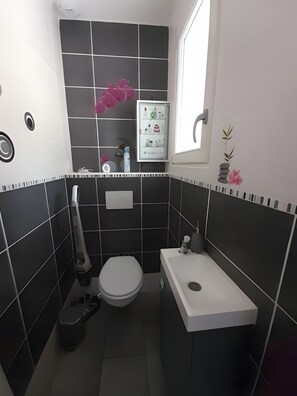Un baño pequeño con inodoro, bidé y lavamanos.