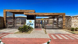 A gated entrance with a sign for 'Gurajuba Villas.' - Casa em Resort c 4 Su tes na Praia de Guarajuba (Camaçari)