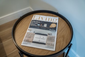 A magazine titled 'Living' on a round wooden table. - Eastfield - Half House (Leyburn)