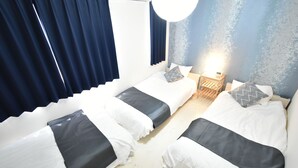 Una camera d'albergo con due letti, un comodino e una sveglia a parete.