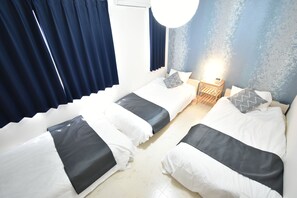 Ett hotellrum med två sängar, ett nattduksbord och en väggklocka.