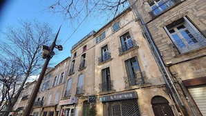 A street view with buildings, a visible storefront, and a streetlight. - Vrbo Property (Pézenas)