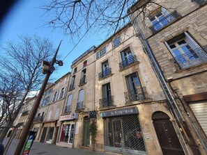 A street view with buildings, a visible storefront, and a streetlight. - Vrbo Property (Pézenas)