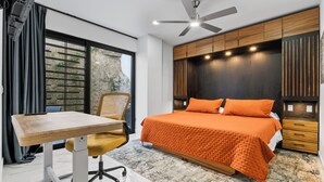 Een moderne slaapkamer met een groot bed, een bureau en een stoel.