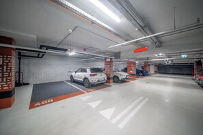 Eine Parkgarage mit mehreren Ebenen, ausgewiesenen Stellplätzen und einer deutlichen Ausfahrtbeschilderung.