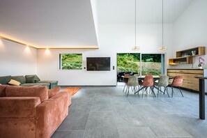 Un espace de vie moderne comprenant un canapé, une table à manger, des chaises et un téléviseur.