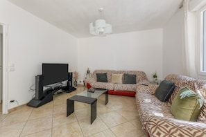 A living room with a sofa set, a TV, and a coffee table. - Le Buquet - Jardin clos de 700 m² (Elbeuf)