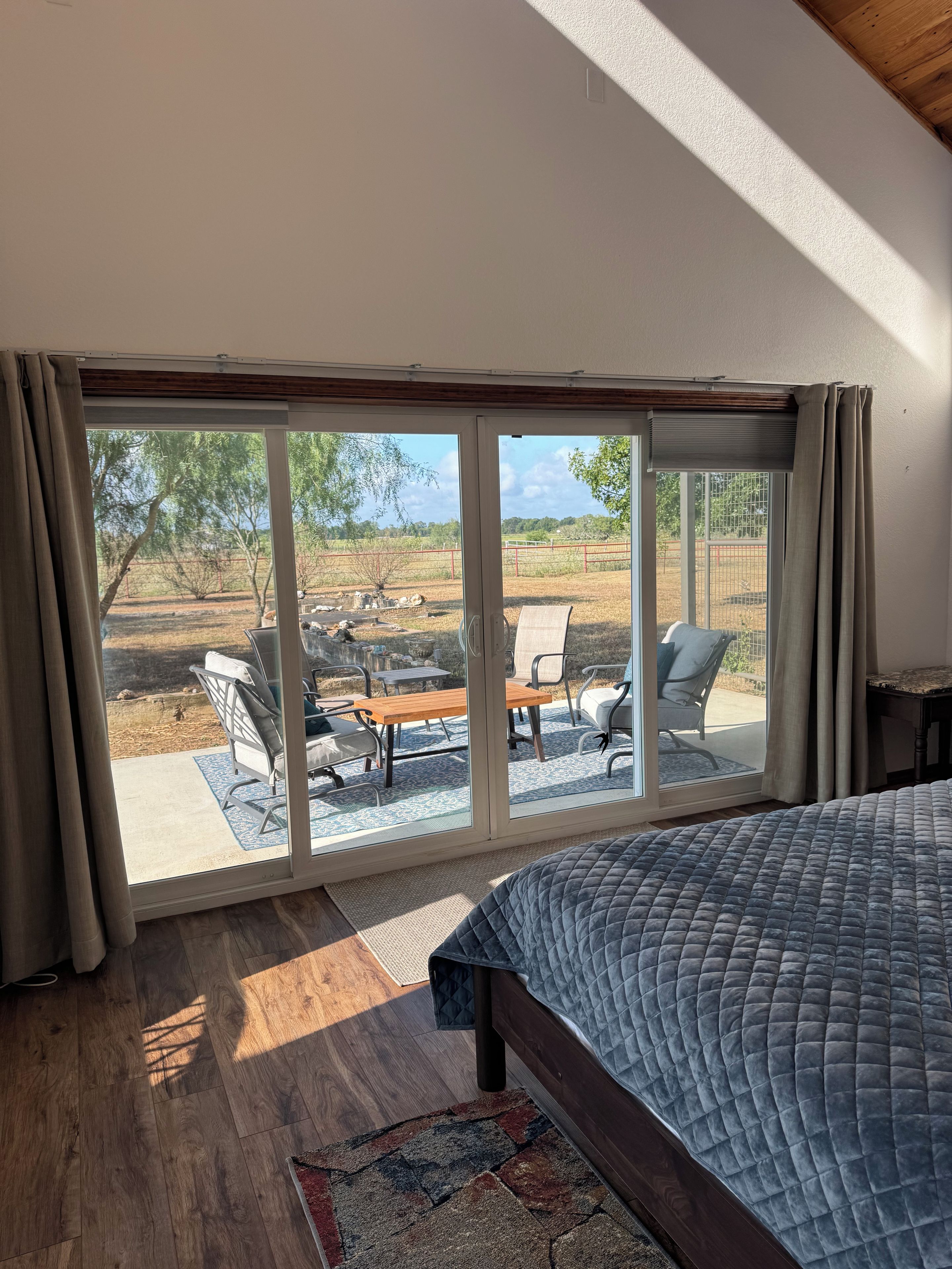 A bedroom with a large sliding glass door leading to an outdoor patio area.