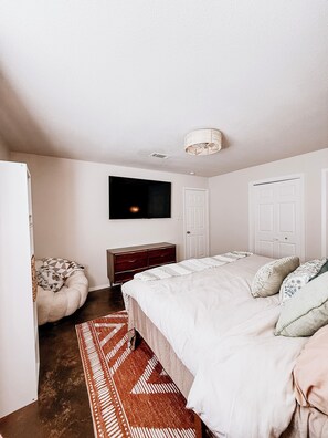 A bedroom with a bed, dresser, and a television mounted on the wall. - Boho-Chic Guesthouse near South Congress w/ 2 King Beds & Free Parking (Austin)