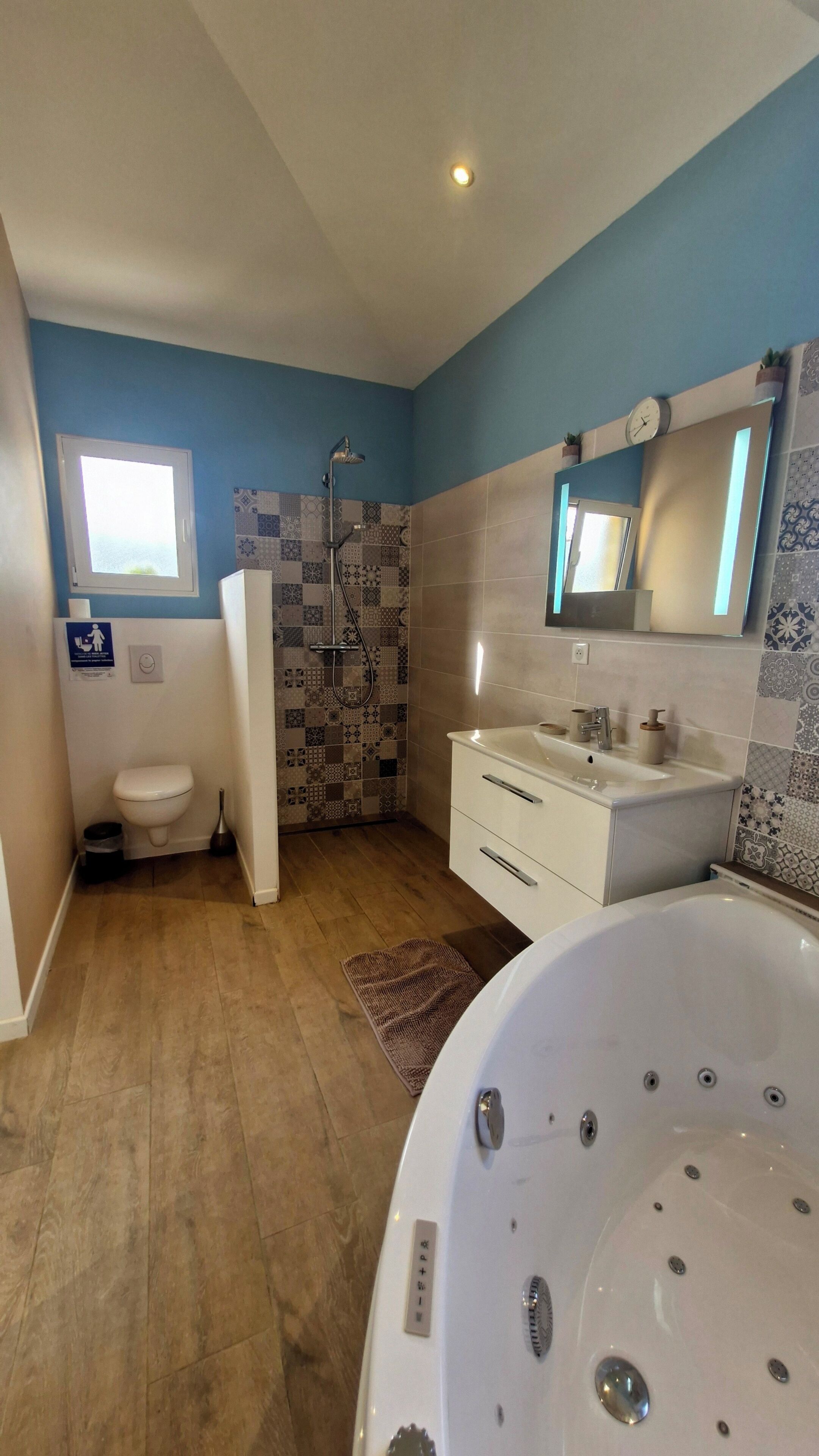Een badkamer met een douche, toilet, wastafel en een ruim bad.