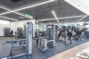 Une salle de sport équipée de divers appareils d’entraînement, notamment des machines à poids et des poids libres.