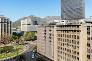 A multi-story building with a modern architectural design, featuring a mix of glass and concrete facades, and a prominent corner entrance. - Charlie and the Chairman | Urban Retreat (Cape Town)