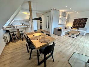 Un espace de vie moderne comprenant un coin repas, une cuisine et un coin salon.