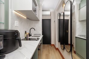 Een moderne keuken met een ingebouwde kookplaat, een spoelbak en een zwarte koelkast.