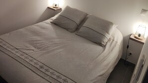 A bedroom with a bed, two bedside lamps, and decorative wall mirrors. - "Gîte Ferrari" 4–6 guests, Ruoms center, shared pool, private terrace, air conditioning (Ruoms)