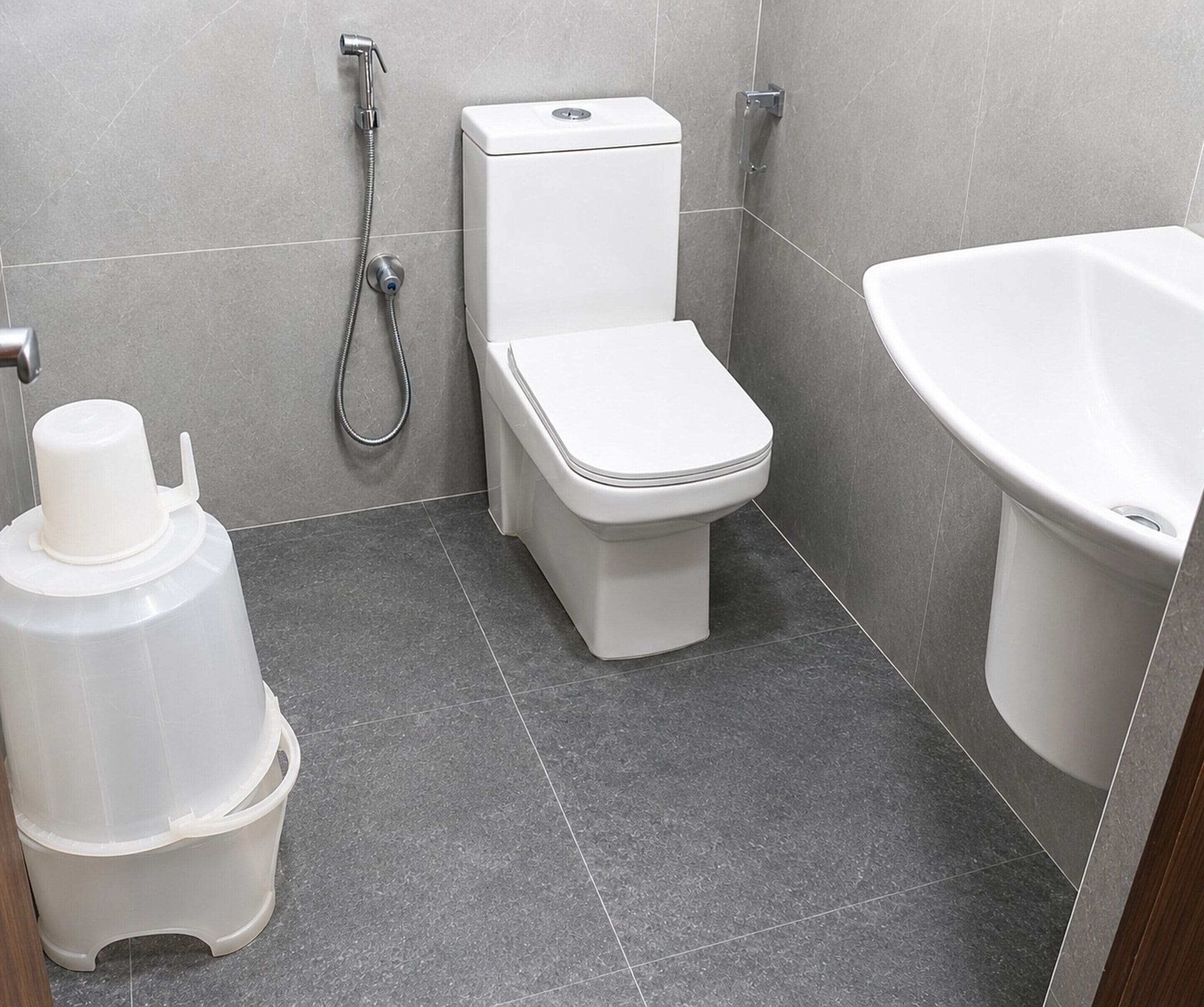 A bathroom with a toilet, a shower, and a sink.