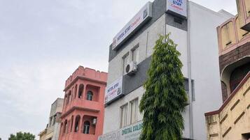 A multi-story building with signs for 'Hotel Stay Comfort' and 'OMEGA Digital Colour'.