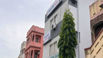 A multi-story building with a sign for 'Hotel Stay Comfort' and another sign for 'Digital Color Photography.'