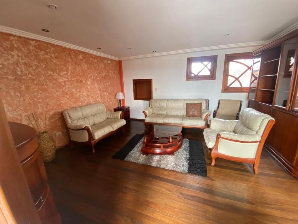 Una sala de estar con un conjunto de sofá, una mesa de centro y un aparador de madera.