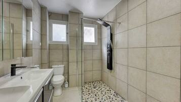 Une salle de bain moderne équipée d’une douche, de toilettes et d’un lavabo.