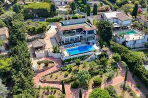 A large property with a swimming pool, multiple buildings, and well-maintained gardens.