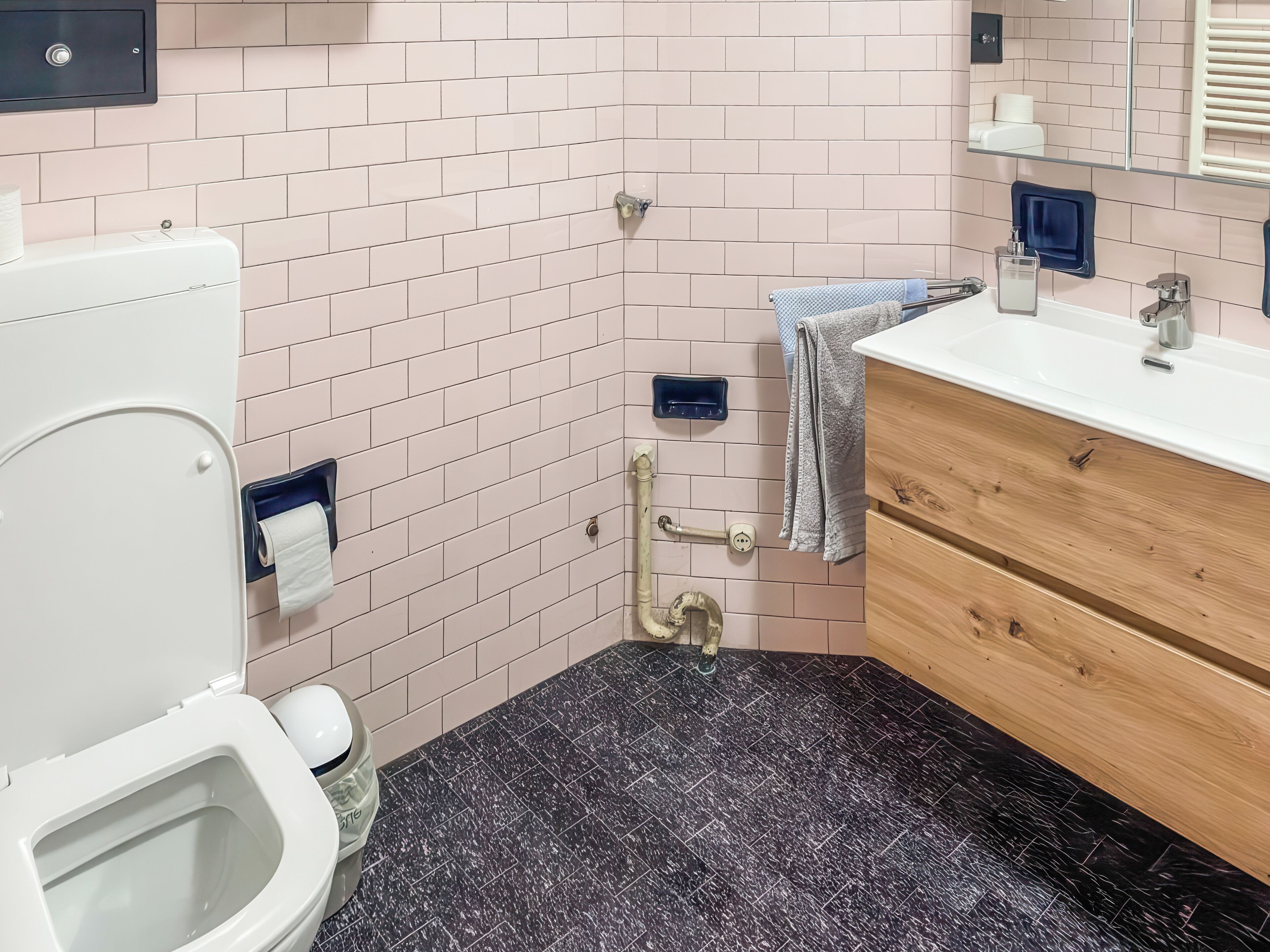 A bathroom with a toilet, sink, and vanity.