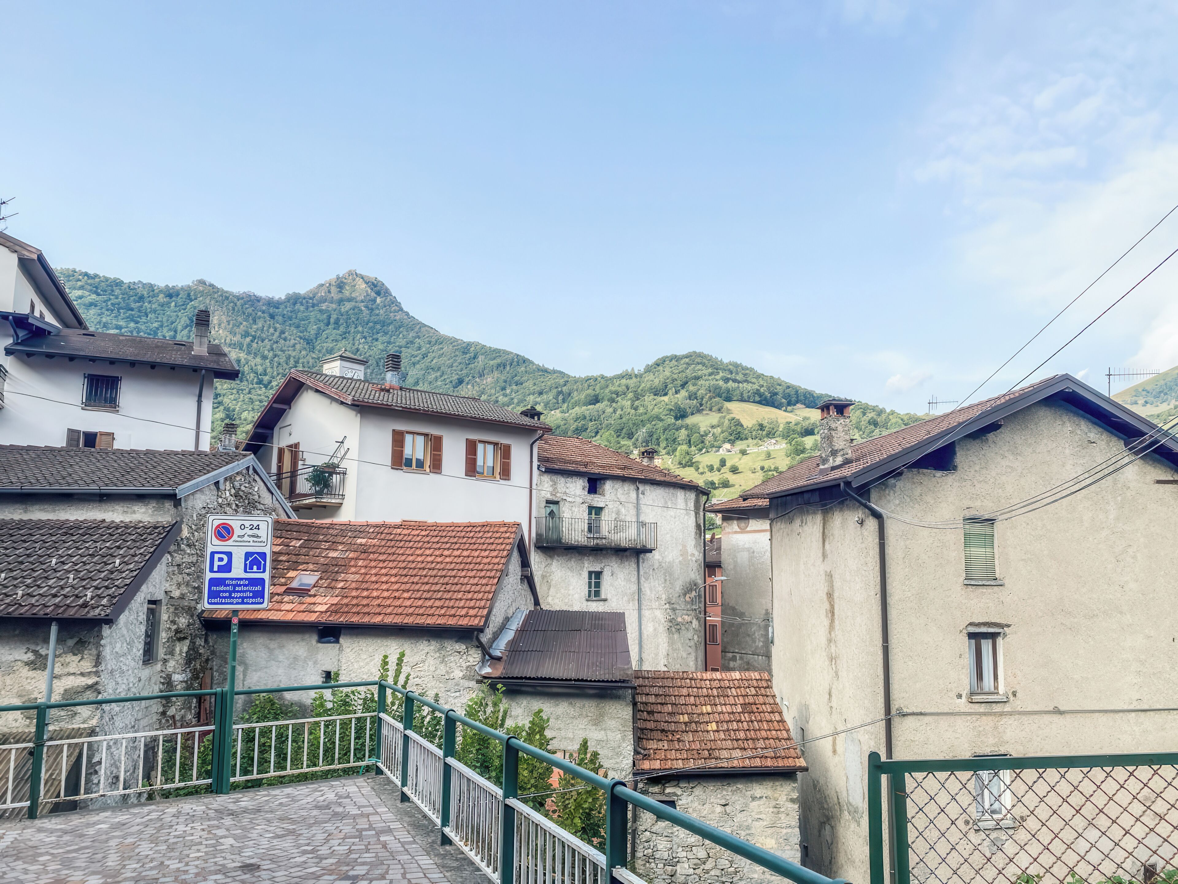 A residential area with buildings, a staircase, and a mountain in the background.