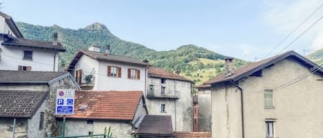 A residential area with buildings, a staircase, and a mountain in the background.