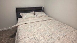 A bedroom with a single bed, a headboard, and a window with blinds. - Cozy 2BR, 1Bath Suite in NW Calgary, Near Airport. (Calgary)