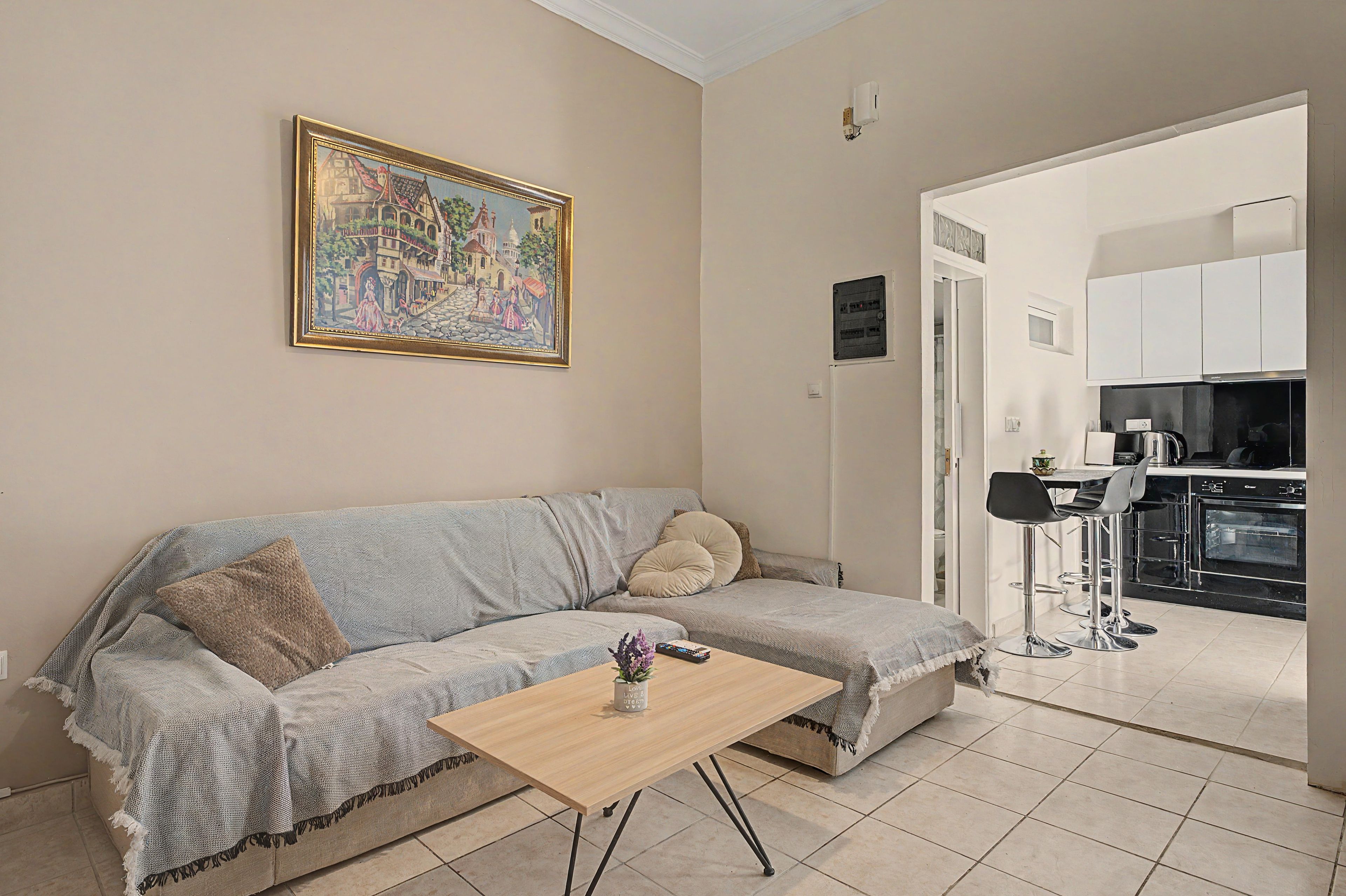 A living room with a sofa, a coffee table, and a painting on the wall.
