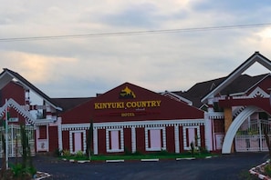 Un edificio con un letrero que dice 'KINYUKI COUNTRY HOTEL' y un logotipo sobre la entrada.
