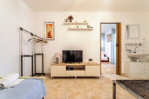 A modern bedroom with a bed, a TV, a desk, and a bathroom. - A1 - Cozy apartment with pool and spacious terrace, 2 min walk to beach (Omiš)