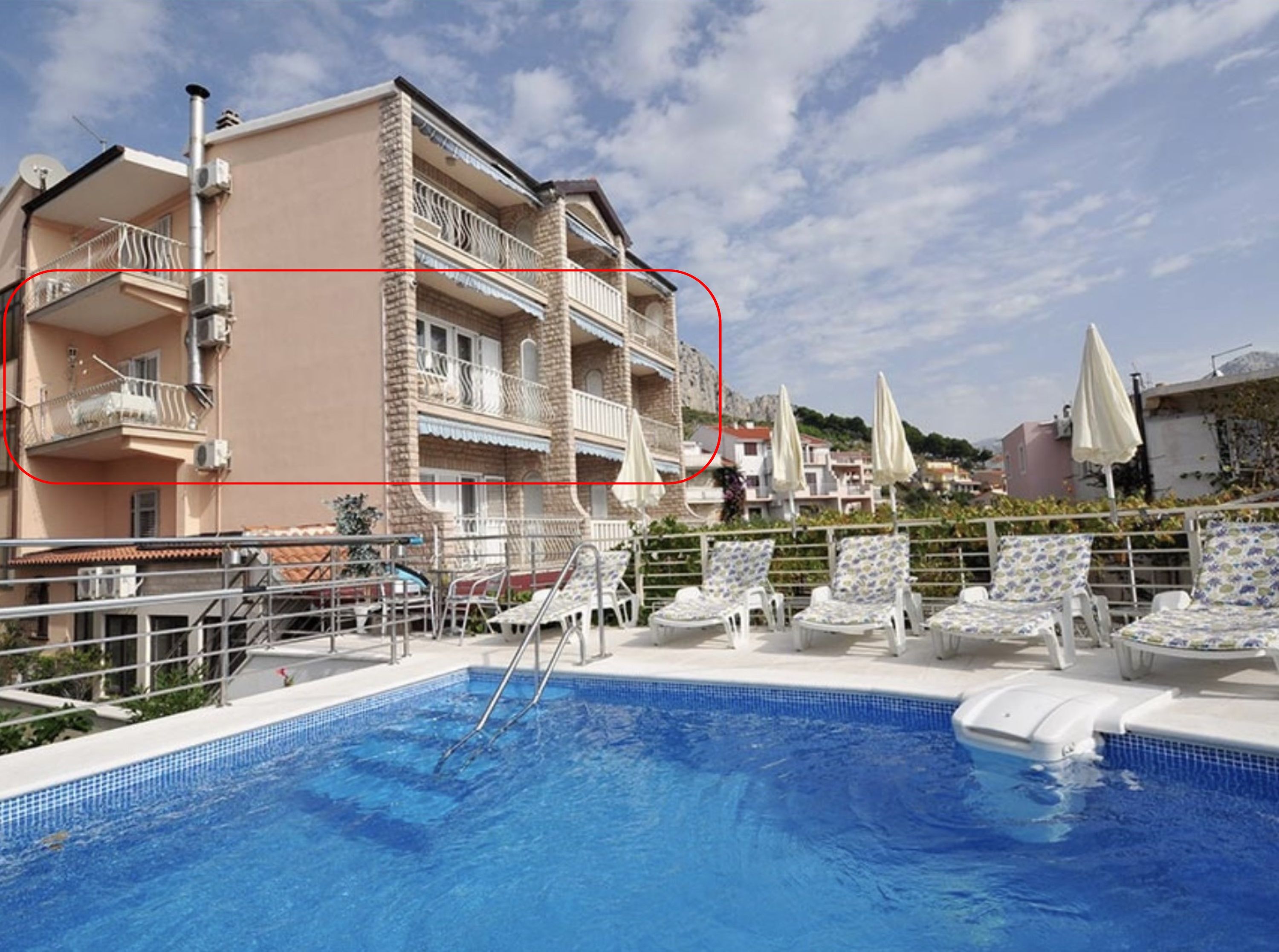 A poolside area with lounge chairs and a swimming pool.