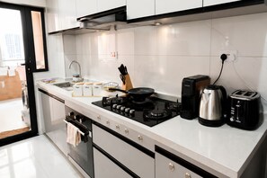 A modern kitchen with a gas stove, coffee maker, toaster, and cabinets. - "Beautiful luxurious spacious 2 bedroom 
apartment with amazing amenities..." (Nairobi)