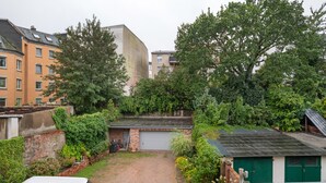 A residential area with a garage, a small shed, and a parked vehicle.